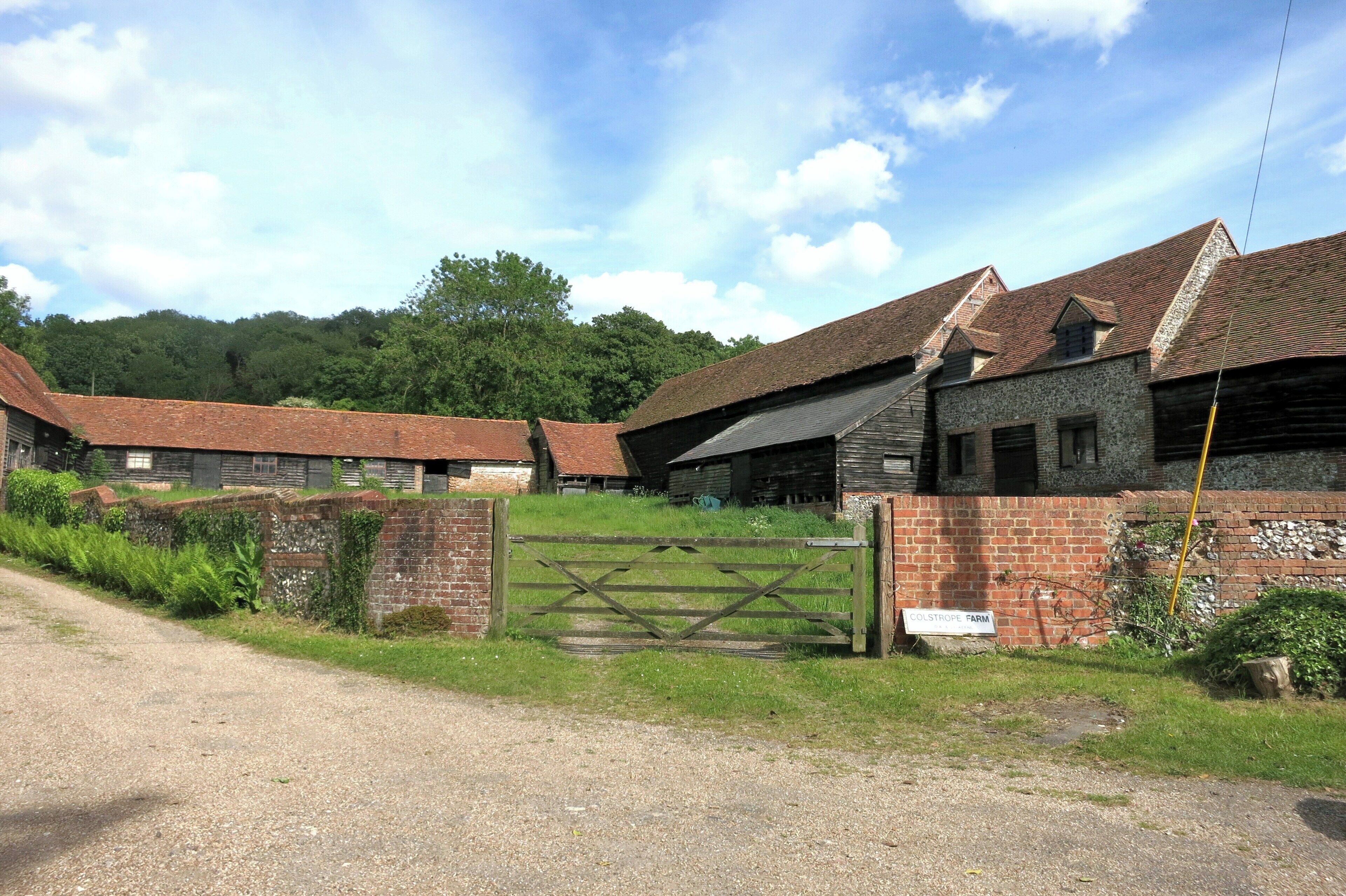 A rural farm with multiple barns and a gravel road.