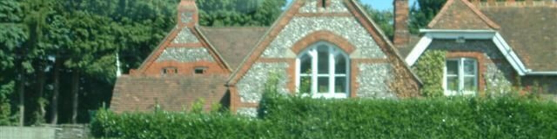 Una iglesia con un campanario, rodeada de vegetación y árboles.