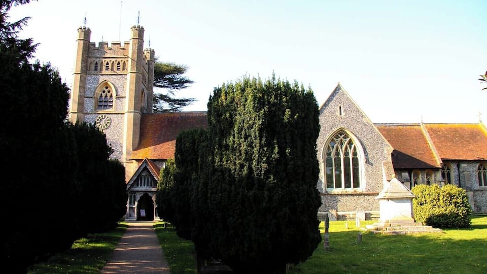 A church with a tall tower and a smaller building with a pointed roof.