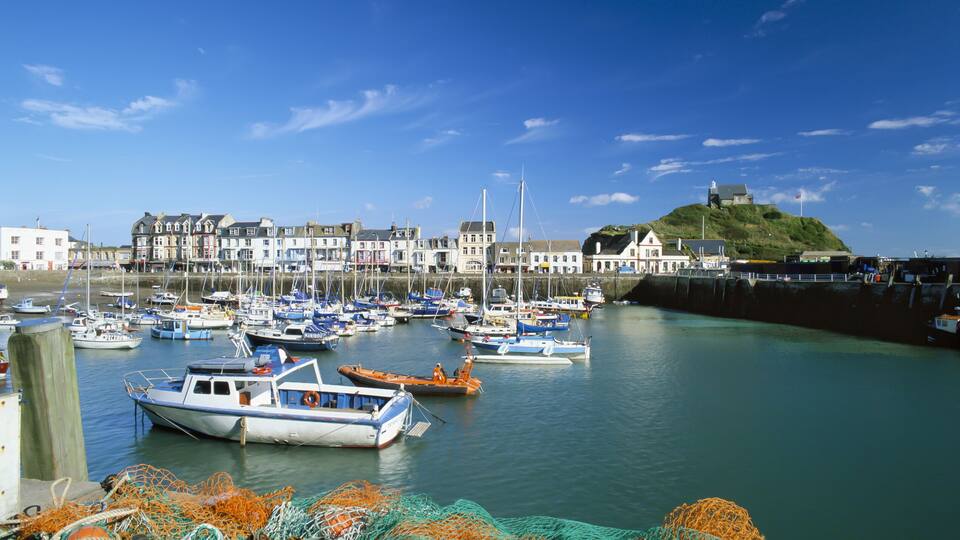 A harbor with boats, fishing nets, and buildings along the shore.
