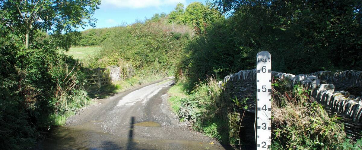 A rural road with a height restriction sign of 6 feet.