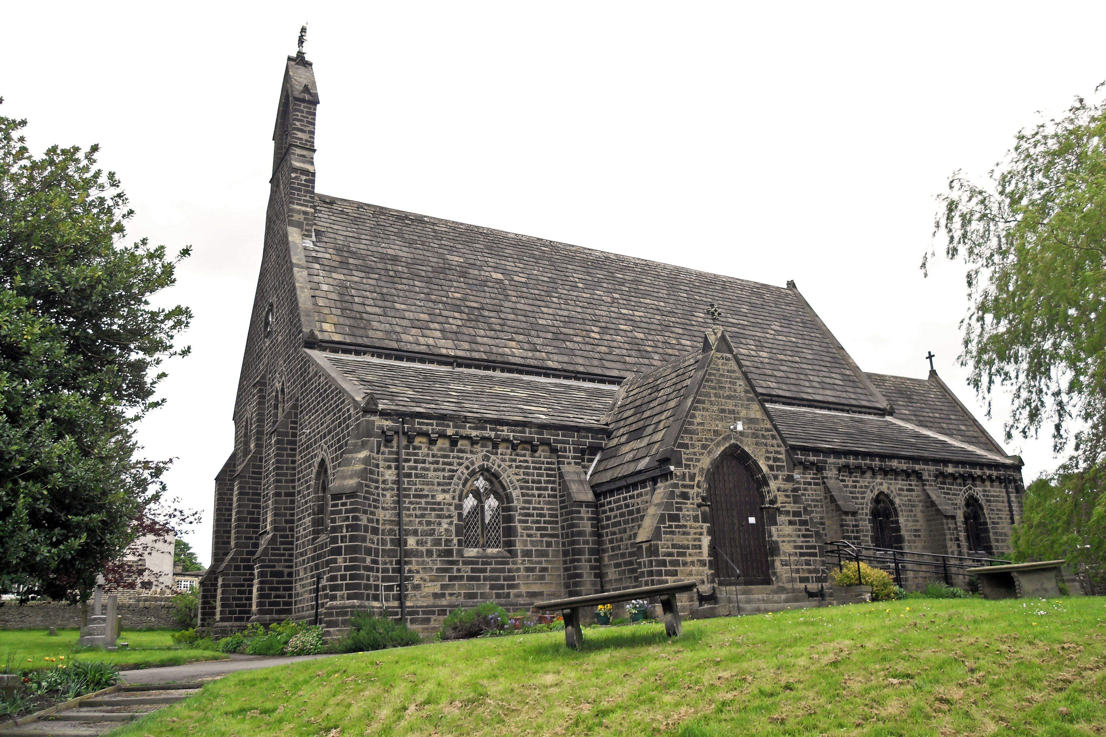 A historic stone church with a tall steeple and arched windows.