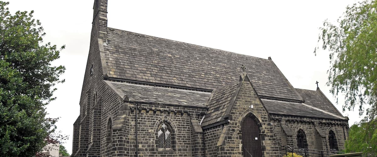 A historic stone church with a tall steeple and arched windows.