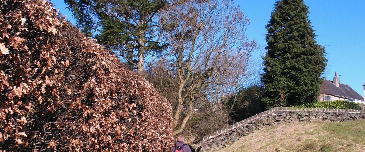 A narrow stone path with a hiker wearing a backpack.