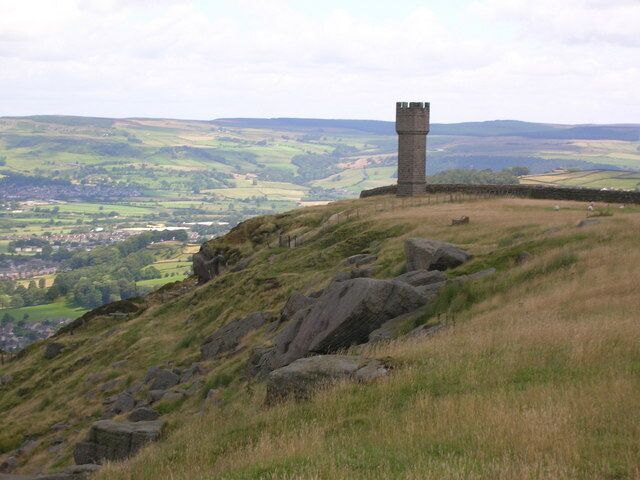 A tower on a hill overlooking a valley.
