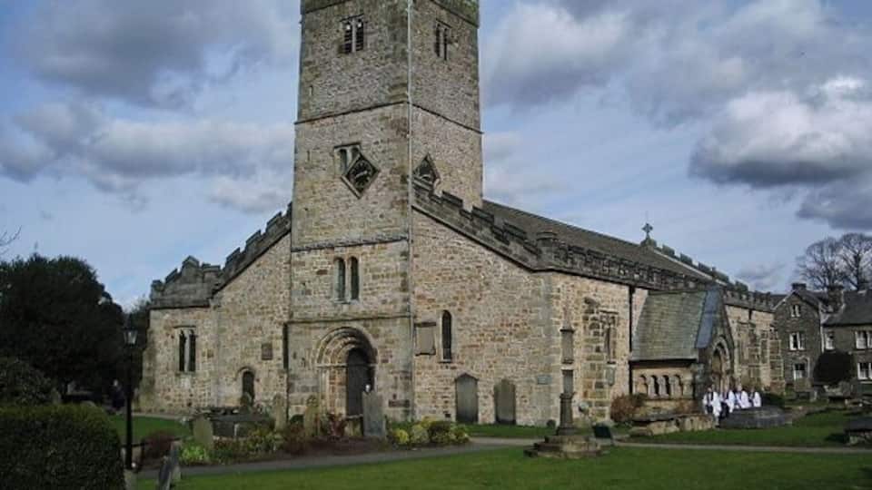 A historic stone church with a prominent tower and arched windows.