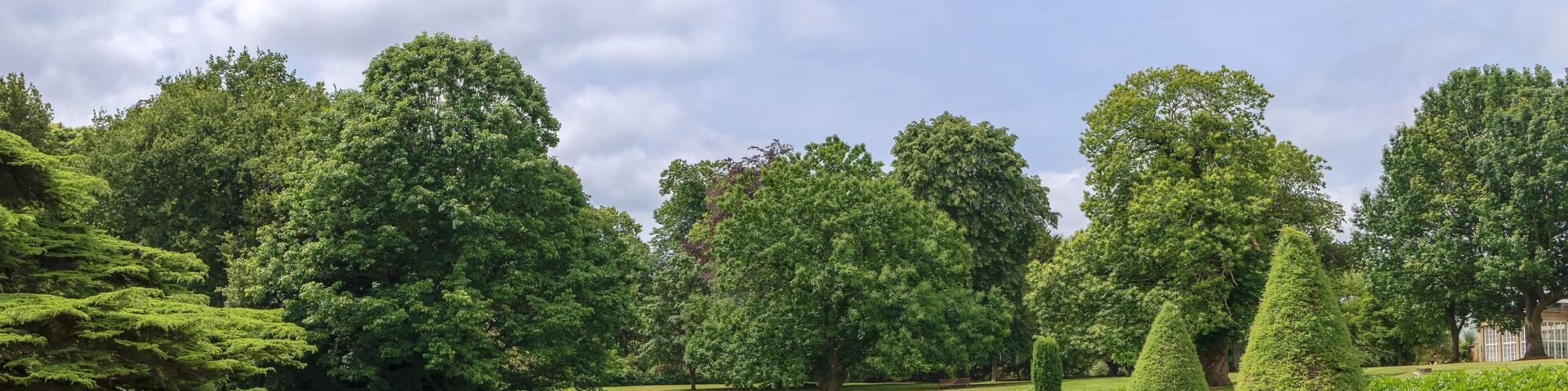 Formal gardens in Tatton Park with stone balustrade, Edwardian tazza planter in the centre of a circular flower bed.