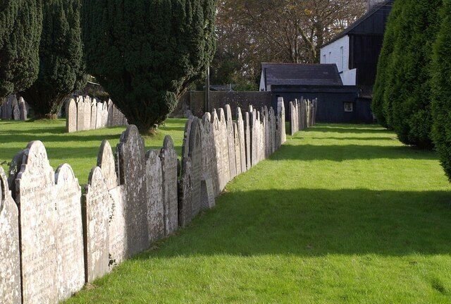 A cemetery with headstones and a building in the background.