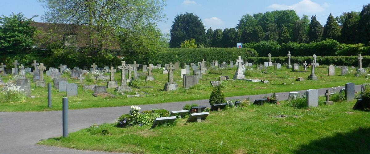 A cemetery with numerous gravestones and a clear sky.