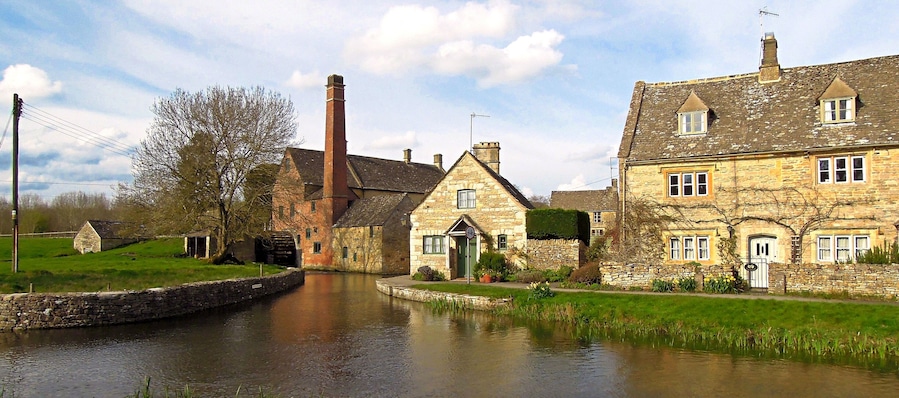 A canal with stone buildings and a water mill.