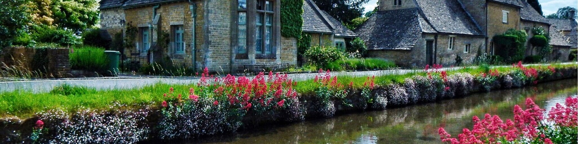 Lower Slaughter is currently my pick for most picturesque village in England that I have seen so far. It is a very small village in the county of Gloucestershire located in the Cotswold District. Through the middle of the village flows the River Eye and from the flower covered banks you can watch the trout swimming in the crystal clear water.
At one end of the village next to the river is The Old Mill which is has a working (not all the time) undershot waterwheel. There is a small museum, craft shop and tearooms which are worth a visit. It is not as busy or touristy as the nearby popular Bourton-on-the-Water this is because there is no parking for the large tour buses which I think help keep the village's charm.