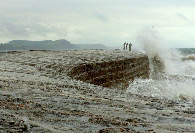 A rocky shoreline with waves crashing against it.