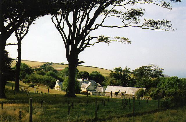 Paisaje rural con colinas onduladas, un árbol grande y una casa pequeña con techo inclinado.