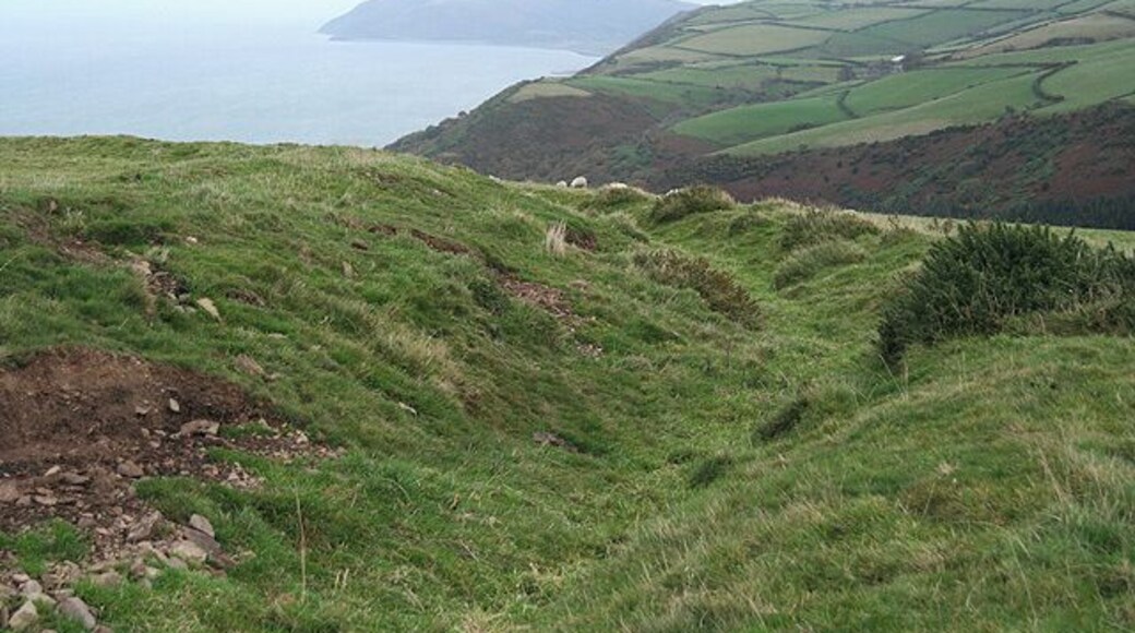 Countisbury: Old Burrow On a rampart of the Roman fortlet which is thought to have been built circa 51 AD and replaced by a fortlet at Martinhoe in circa 55 AD. Of the two Old Burrow is the better preserved. The two camps, probably only garrisoned in the summer months, served to keep watch on the hostile Celtic tribe, the Silures, who inhabited the Welsh coast on the far side of the Bristol Channel. Looking east-north-east along the coast to Hurlstone Point, beyond Porlock