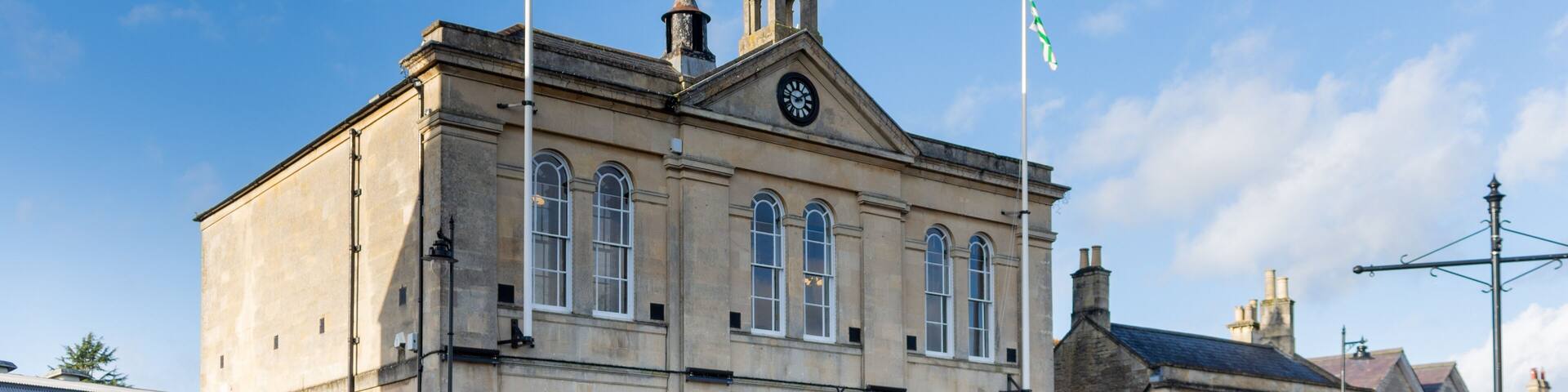 Melksham Town Hall against a blue winter sky with flags flying on a sunny winter late afternoon