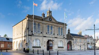 A historic building with arched windows and a clock tower, surrounded by a clear blue sky.