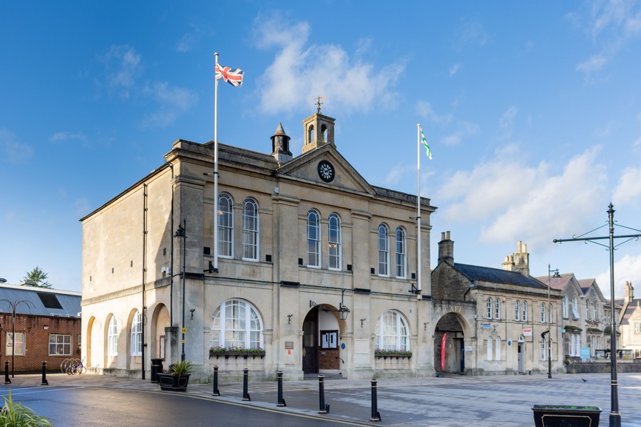 A historic building with arched windows and a clock tower, surrounded by a clear blue sky.