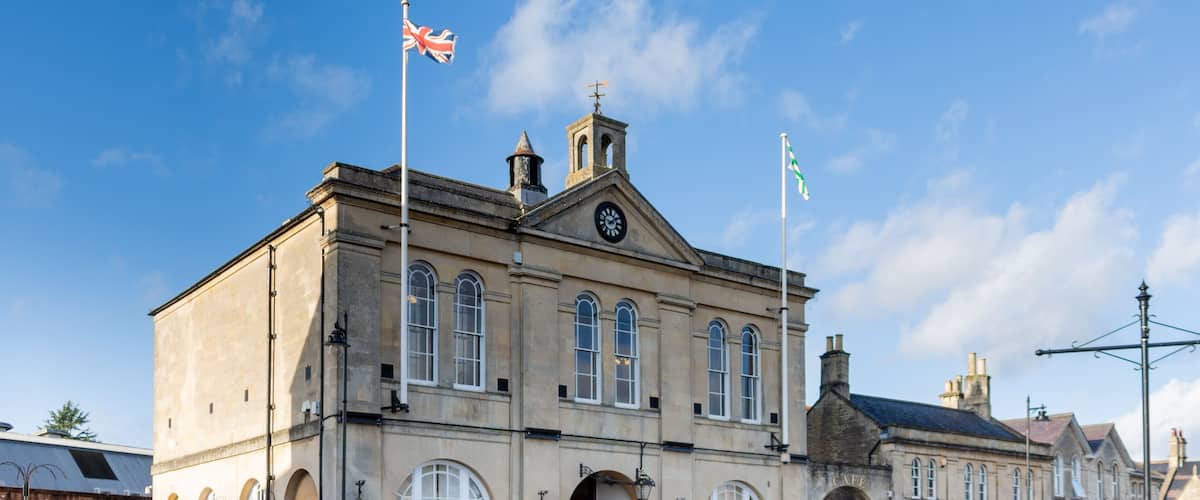A historic building with arched windows and a clock tower, surrounded by a clear blue sky.