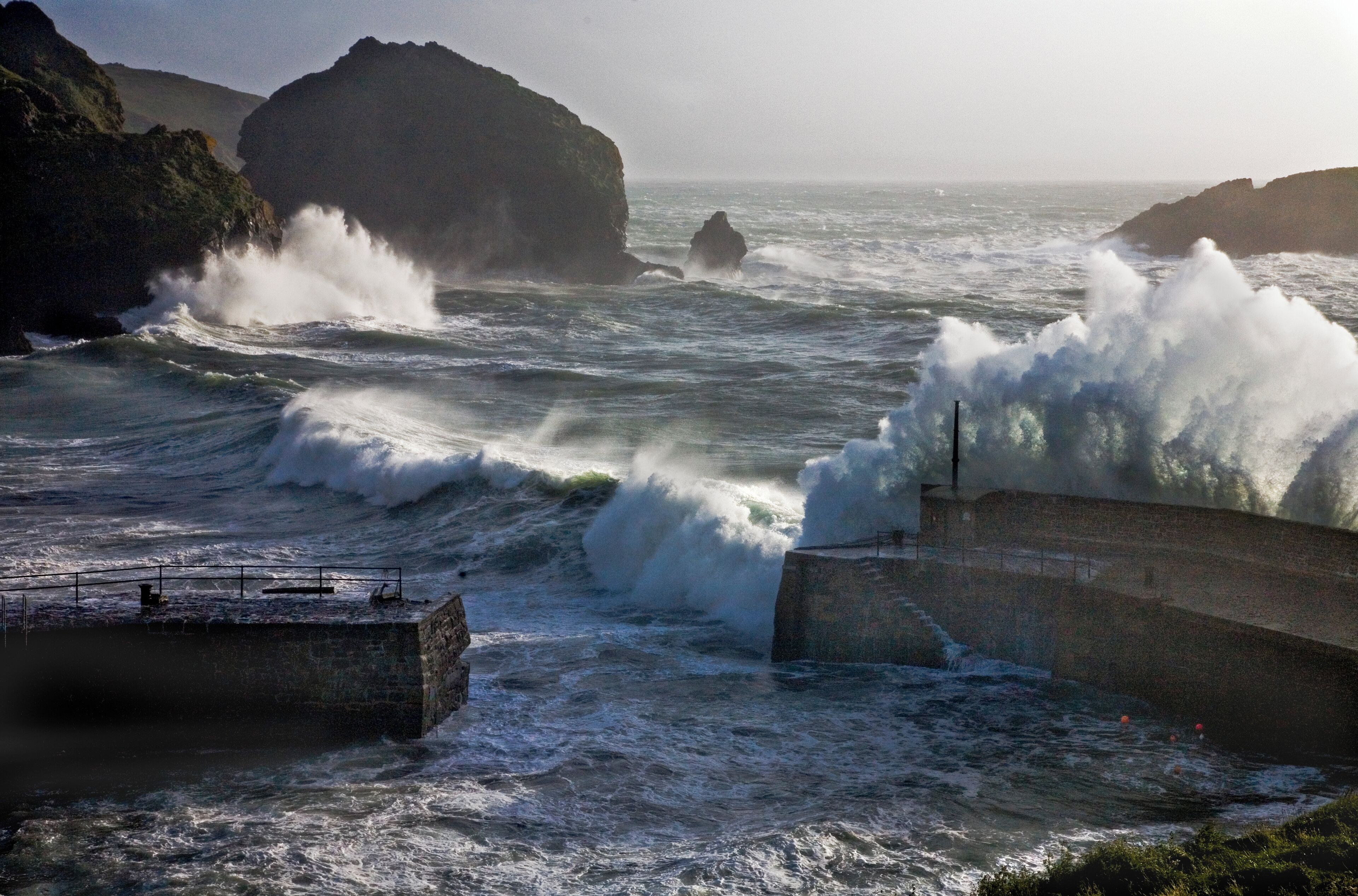 A rocky coastline with waves crashing against a sea wall.
