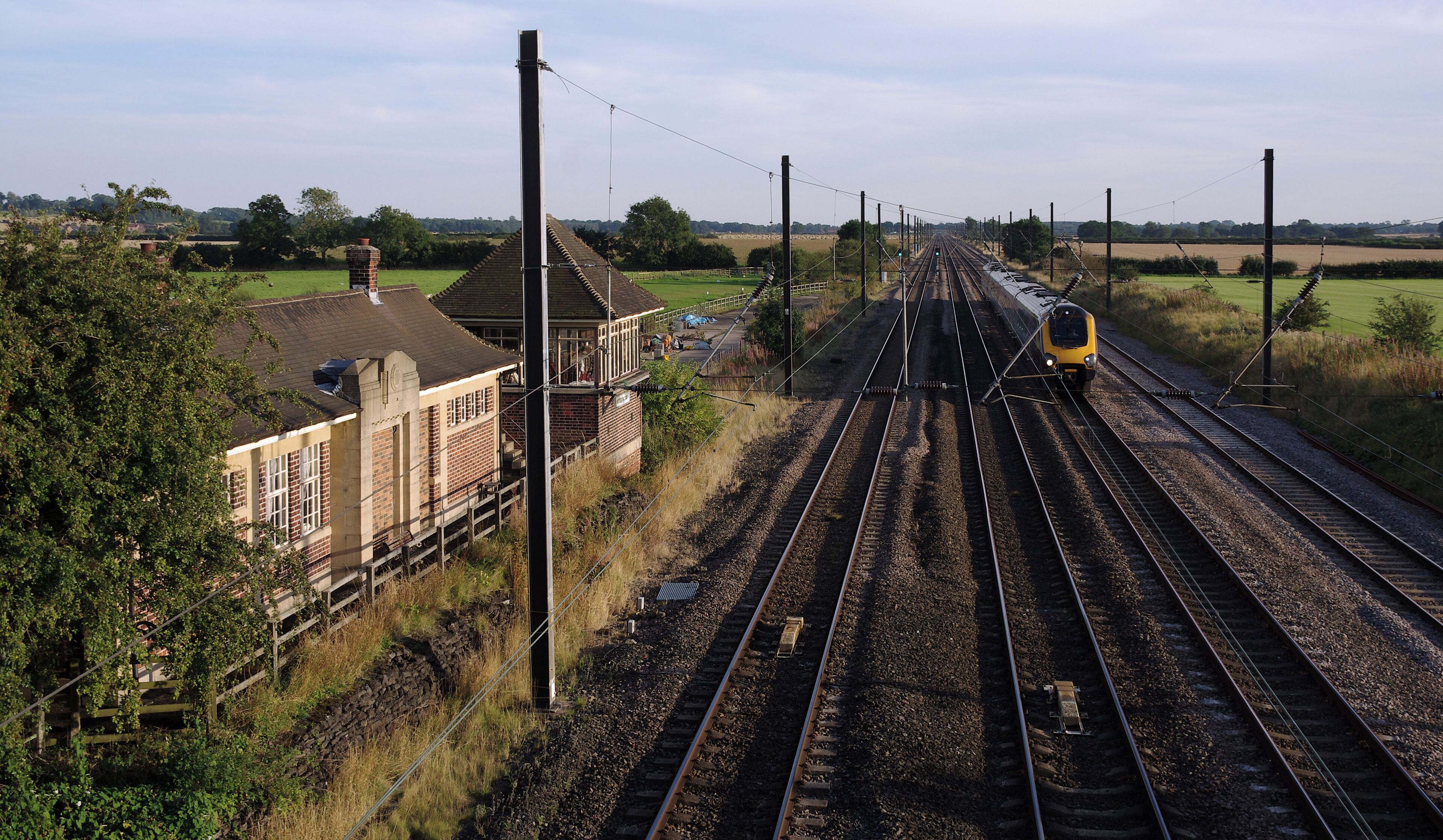 A CrossCountry Class 220 "Voyager" DEMU speeds north past the disused Otterington railway station on the East Coast Main Line.