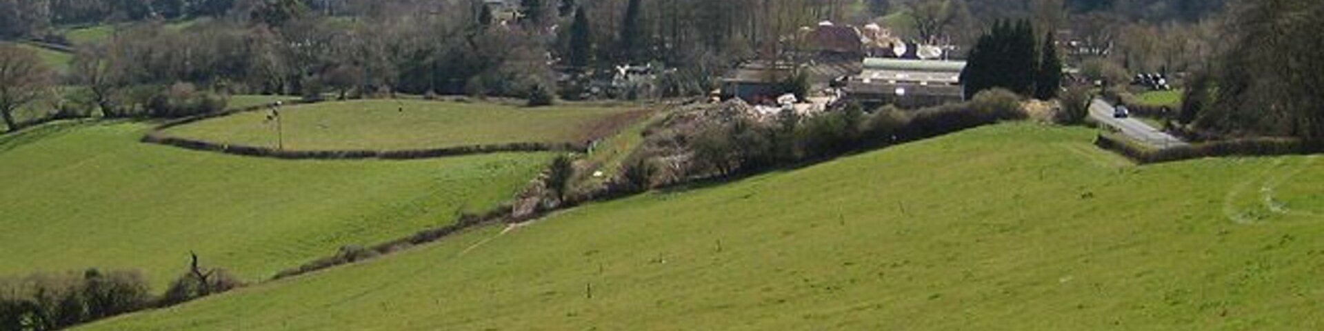 Grange Village from Dean Hill The road heads down to Newnham-on-Severn. The Severn makes it way round the great horseshoe bend and on to Bristol. Sand/mudbanks are exposed so it must be low tide.