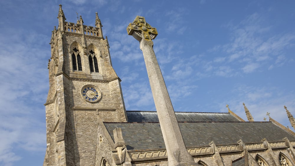 Une église historique dotée d’un haut clocher et d’un imposant monument en pierre.