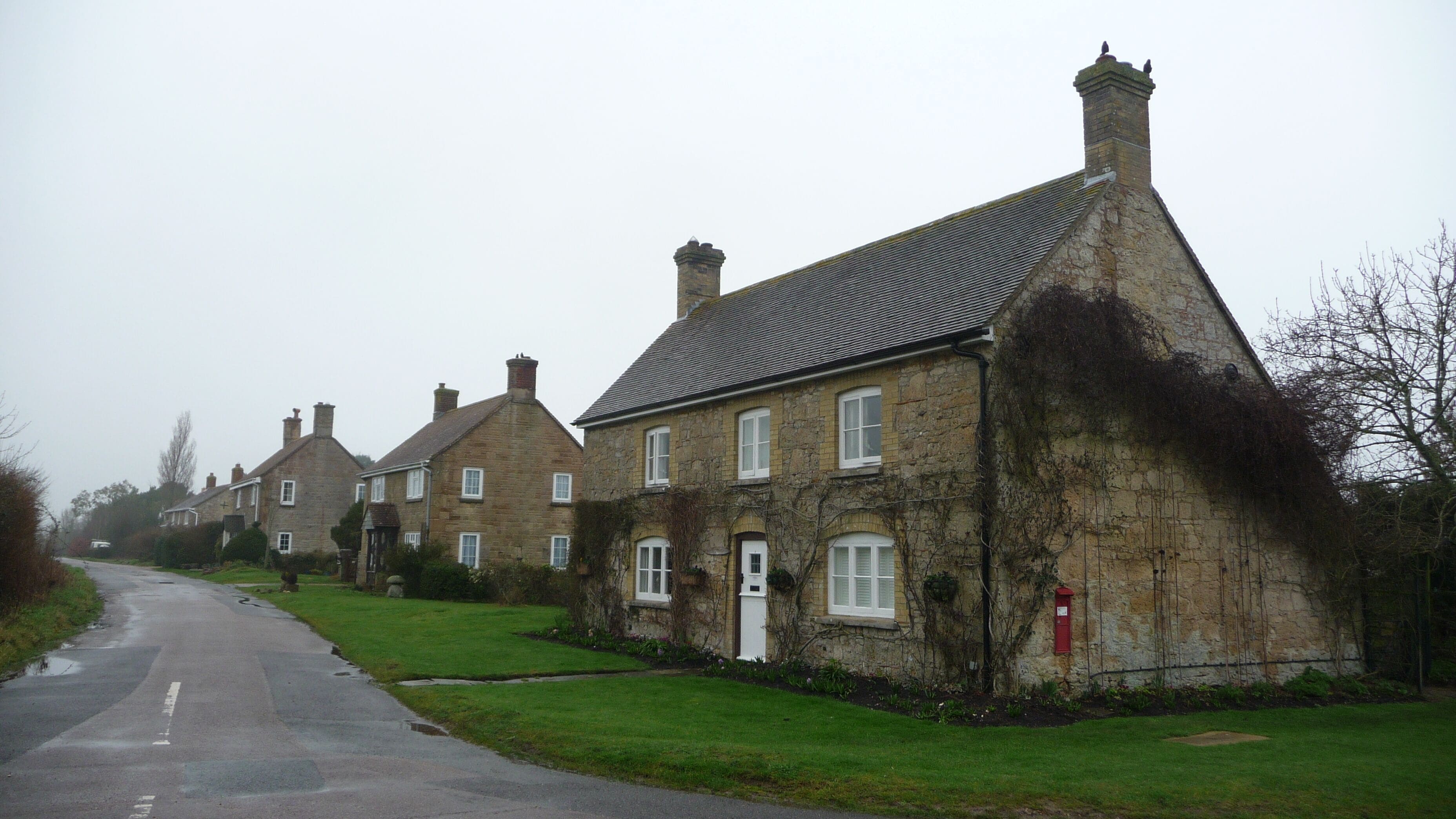 A row of houses along a side road off Town Lane, Newtown, Isle of Wight. Note the end house has a post box built into its wall.