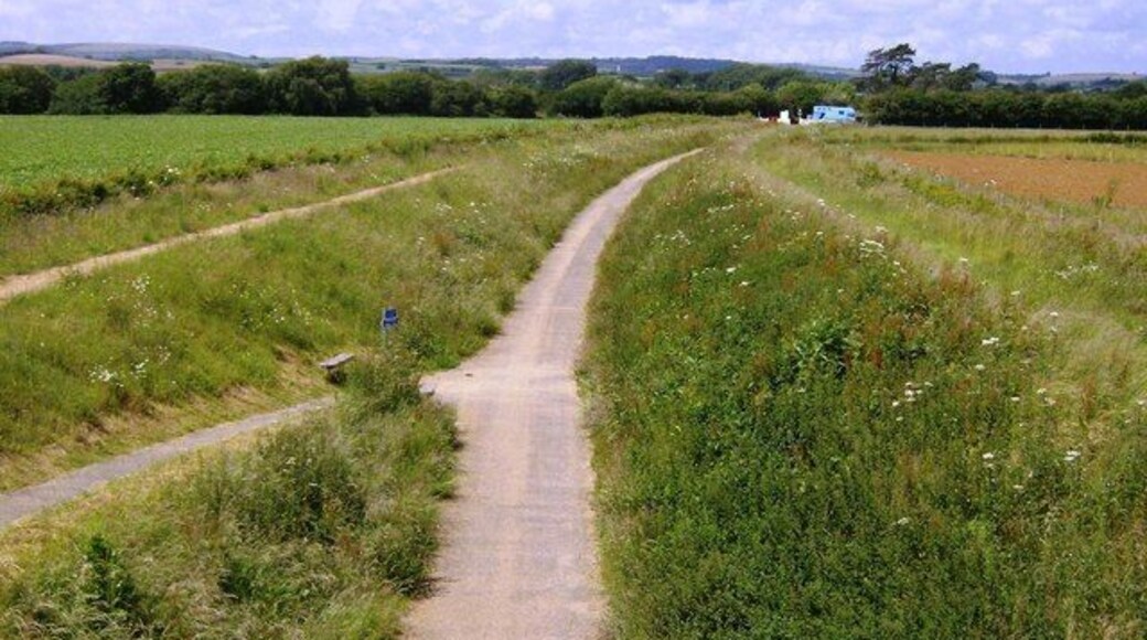 NCN 23, near to Merstone, Isle of Wight, Great Britain. Looking north-west towards Newport, this is the former Sandown to Newport railway line now used as a cycle trail. The minor road crossing here still uses the original bridge, whilst the crossing in the distance by the blue horsebox (Merstone Lane) is a former level crossing.