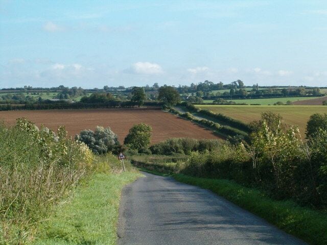 Rural Road The road from Stoke Goldington to Ravenstone as it dips into a small valley with a brook.