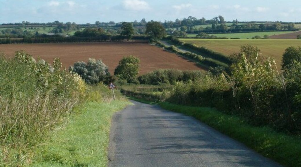 Rural Road The road from Stoke Goldington to Ravenstone as it dips into a small valley with a brook.