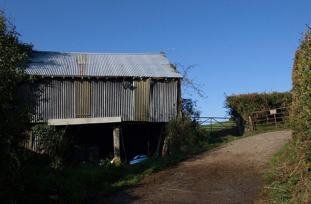 Barn at Mill Farm A corrugated iron barn by the farm road carrying Drewsteignton Footpath 8 up from the Fingle Brook valley towards the A382.