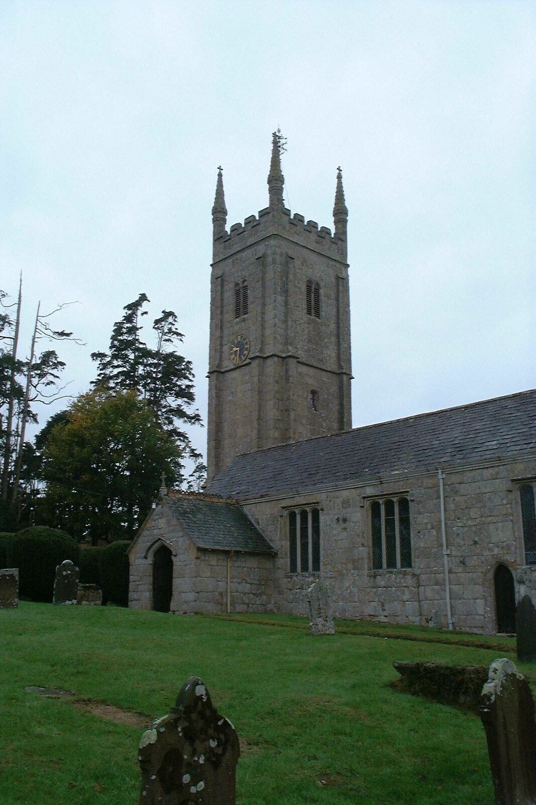 A church with a tall clock tower and a small adjacent building.