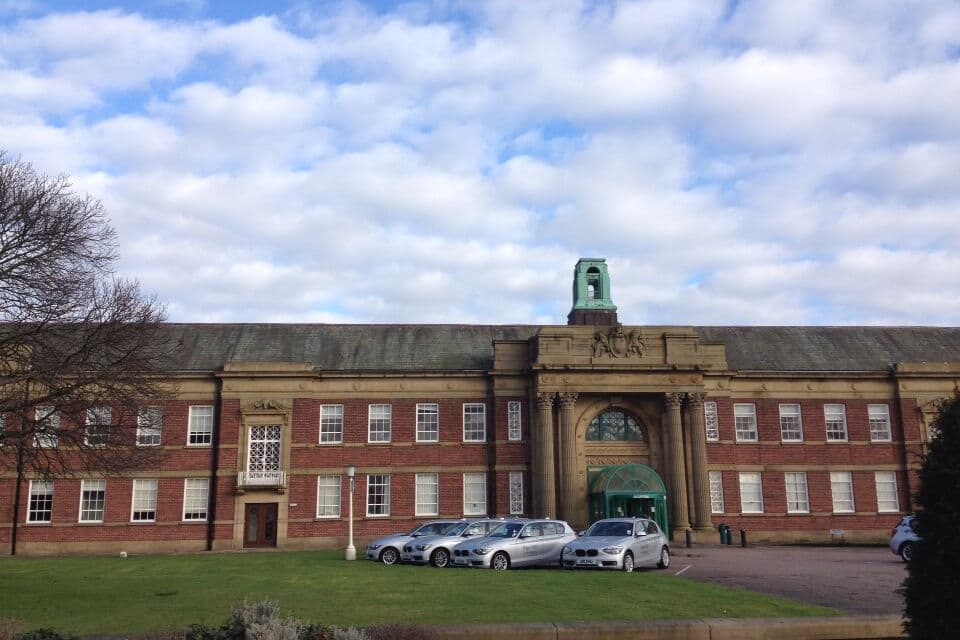 A large brick building with a prominent entrance and a clock tower.