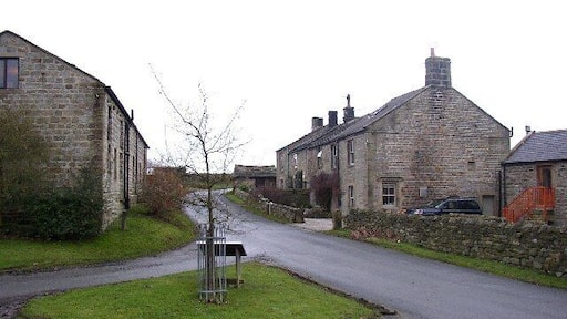 The western end of Timble Village. Here there is a little green with an information board about the area (although in the village it only mentions an old oak). To the left a little lane leads down to some houses and a farm.