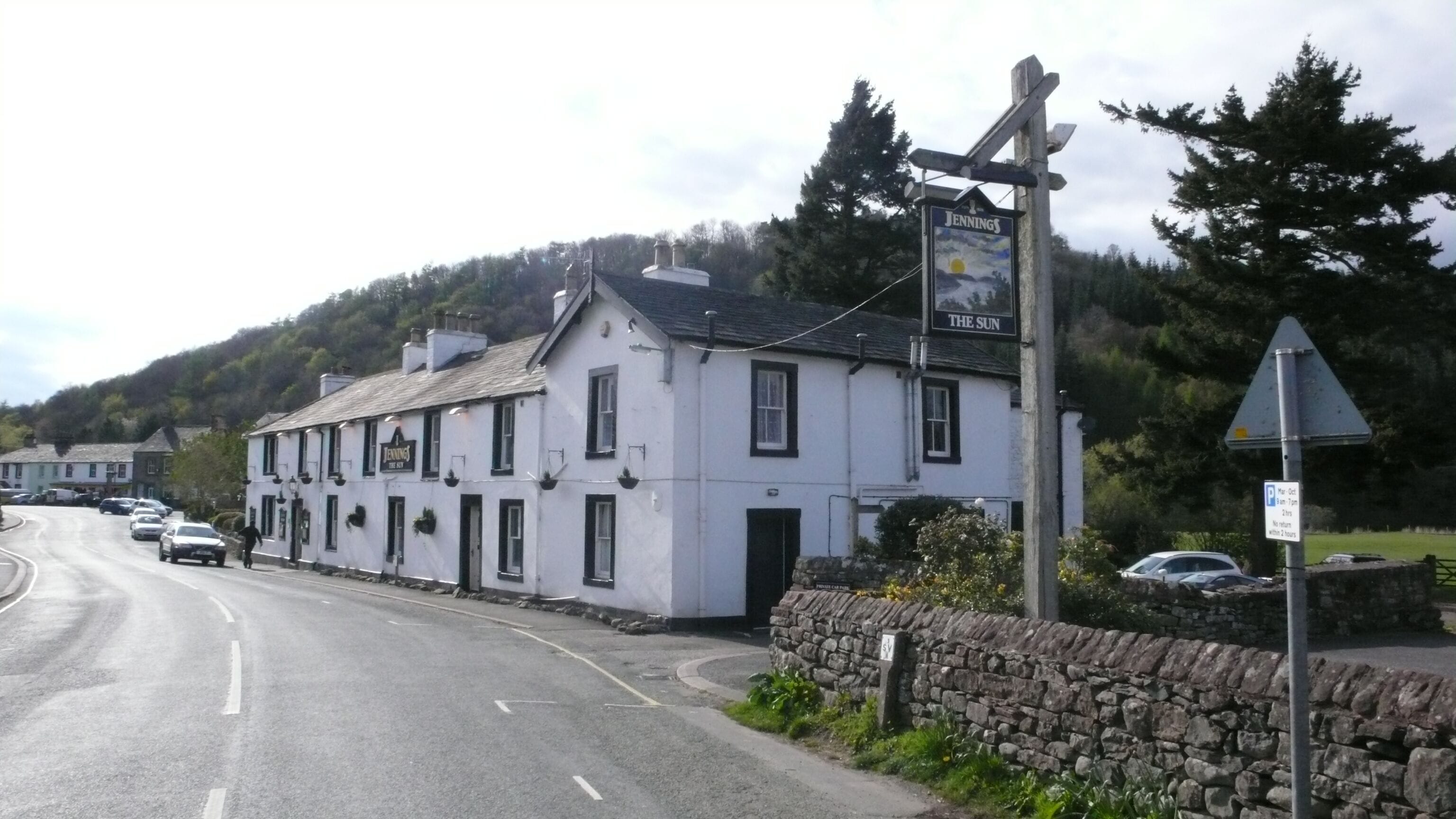 Un pub blanco llamado 'Jennings' con un letrero que dice 'Jennings The Key' y 'The Sun'.