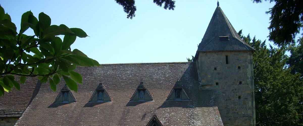 A stone church with a tower and a covered entrance.