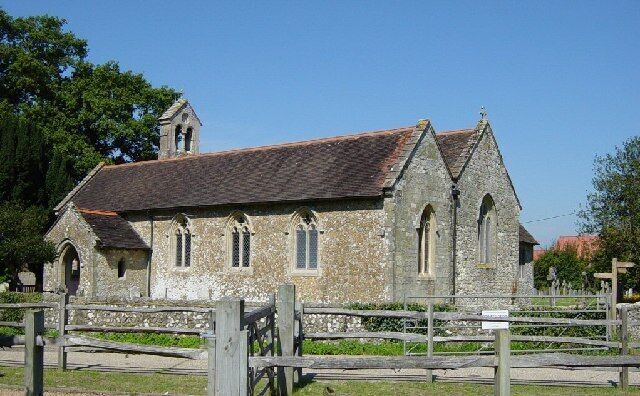 A stone church with a tiled roof and a bell tower.
