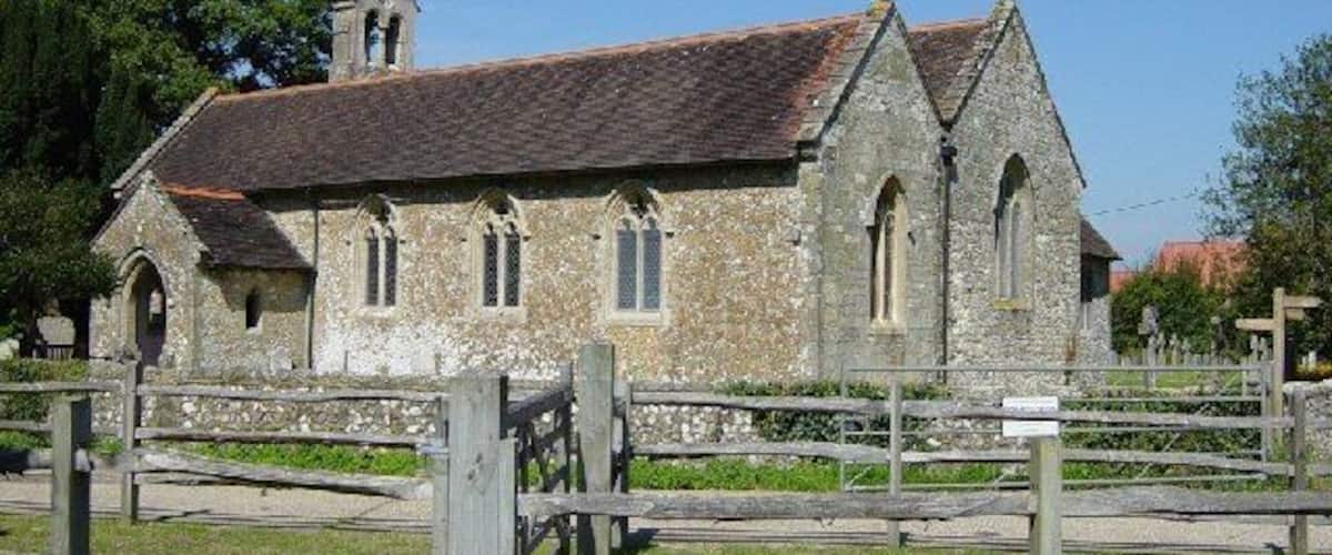 A stone church with a tiled roof and a bell tower.