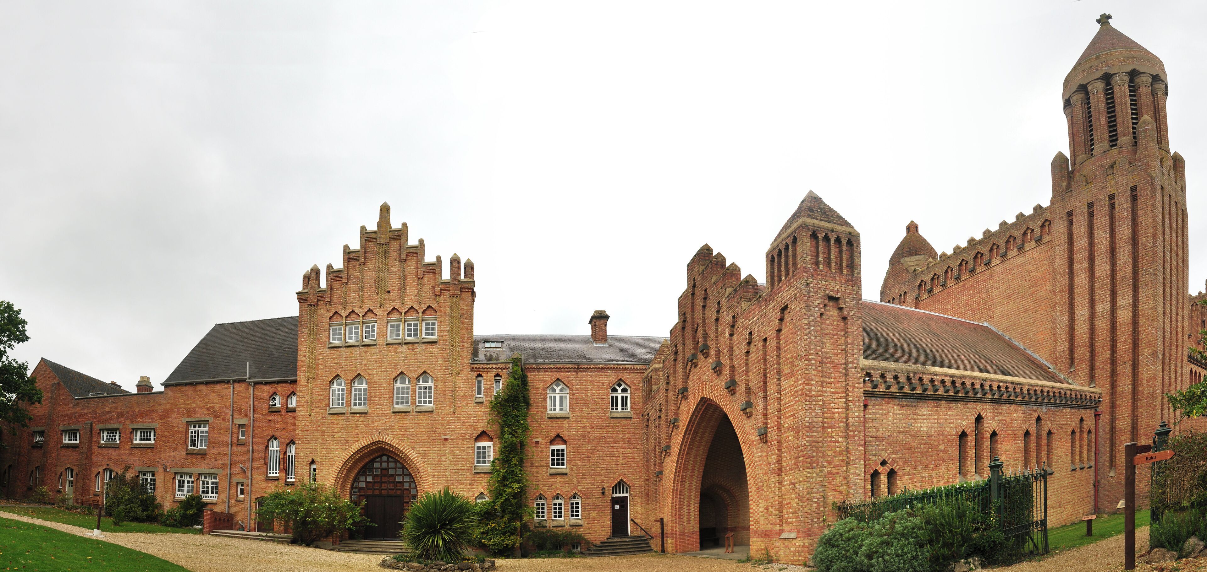 A large brick building with a prominent tower and arched entrance.