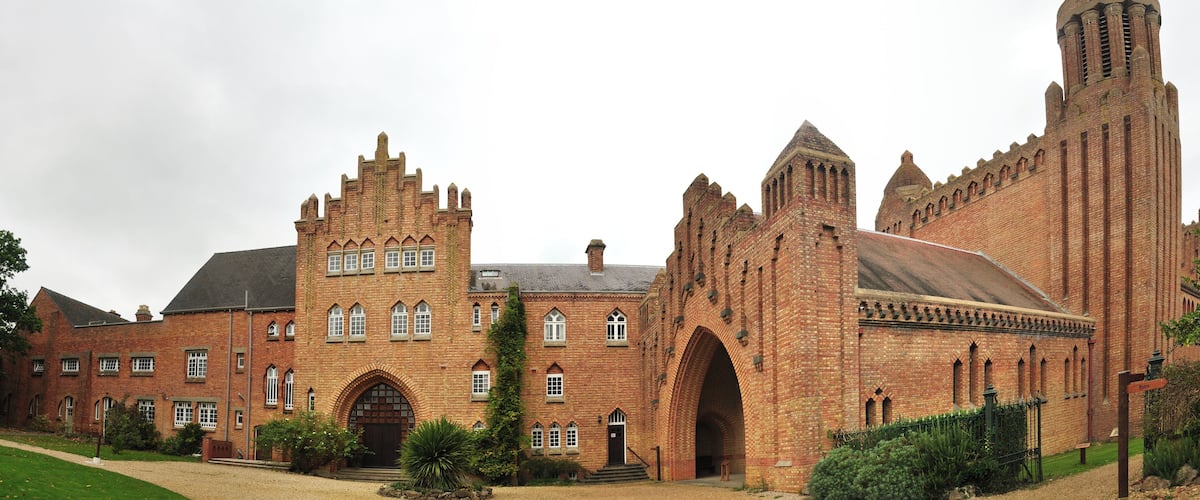 A large brick building with a prominent tower and arched entrance.