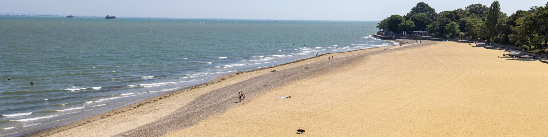 Wide sandy beach at Appley Beach in Ryde on the Isle of Wight with gentle waves along the shoreline and a peaceful summer coastline creating a relaxing seaside landscape beneath a clear blue sky