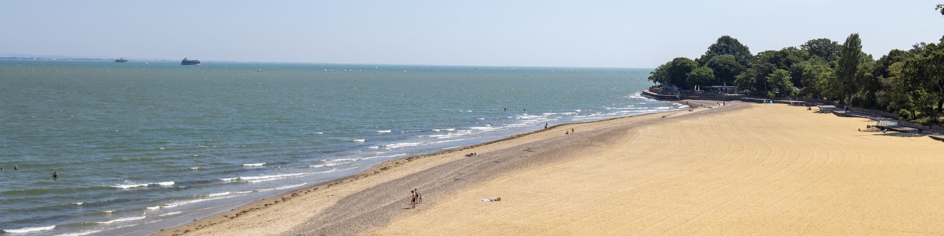 Wide sandy beach at Appley Beach in Ryde on the Isle of Wight with gentle waves along the shoreline and a peaceful summer coastline creating a relaxing seaside landscape beneath a clear blue sky