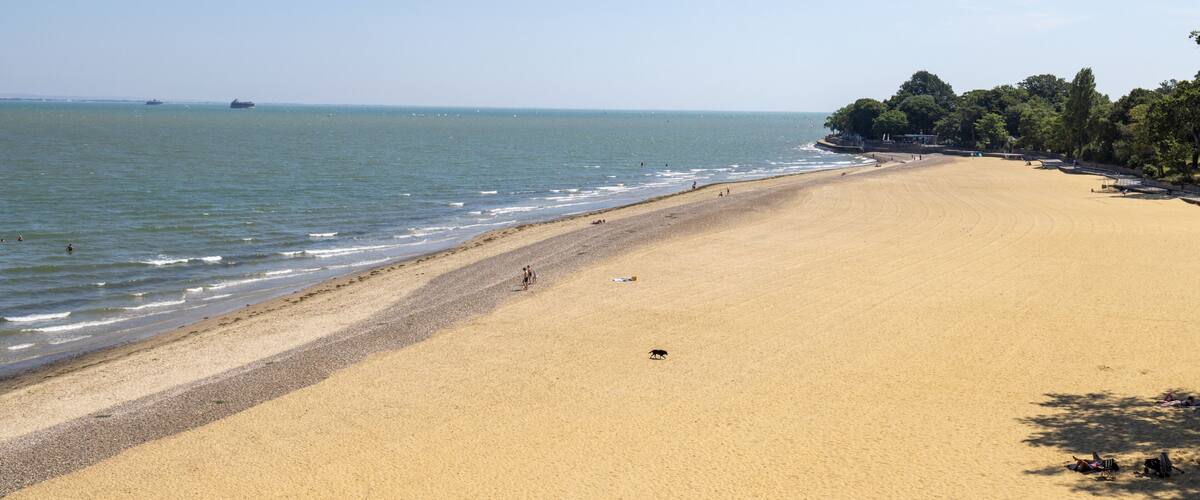 Wide sandy beach at Appley Beach in Ryde on the Isle of Wight with gentle waves along the shoreline and a peaceful summer coastline creating a relaxing seaside landscape beneath a clear blue sky