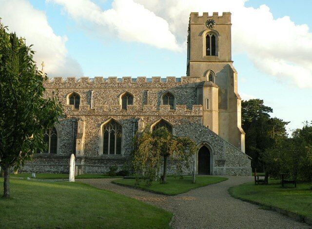 A stone church with a clock tower and arched windows.