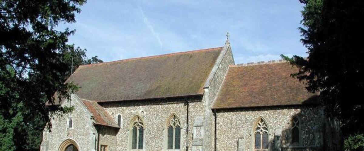 A stone church with a steeply pitched roof and arched windows.