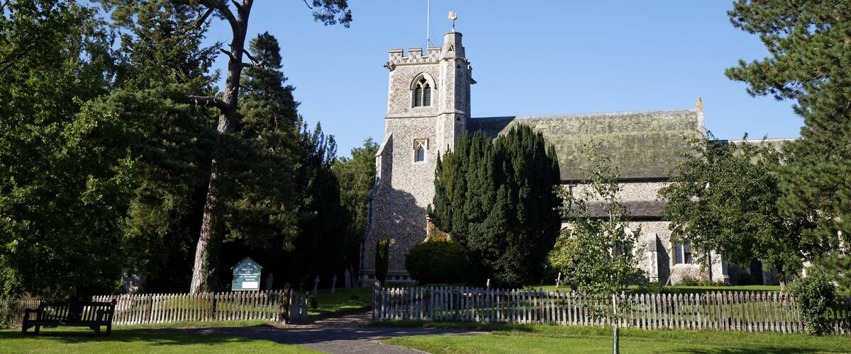 A church with a tall tower and a stone building.