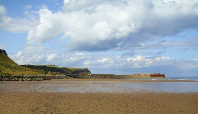 Skinningrove beach and jetty A wide expanse of sand leading towards the old jetty, once used by the nearby ironworks at Carlin How.