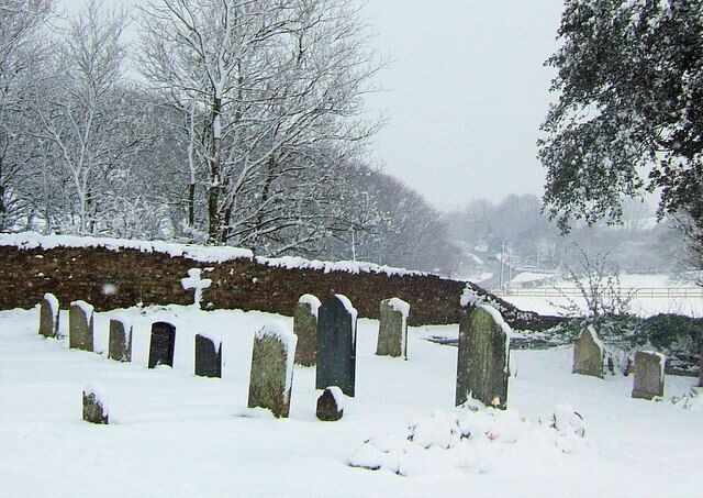 Bishopstone Road from St Andrew's Churchyard, Bishopstone, East Sussex A car can just be seen approaching Bishopstone along the wet road.