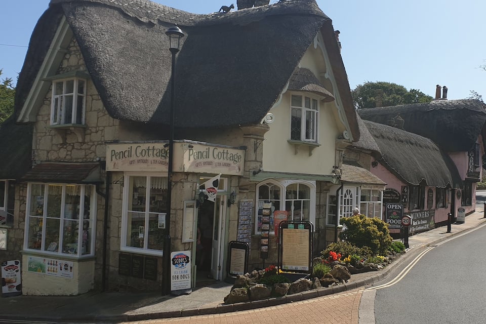 Un bâtiment traditionnel à toit de chaume, appelé « Cottage au crayon », qui abrite une boutique et un jardin où l’on sert du thé.