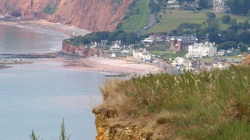A coastal town with cliffs, a beach, and houses.